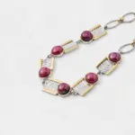 ONDA LENTA two-tone statement necklace featuring round pink cabochon gemstones and sculptural silver-tone textured links with gold-tone accents.