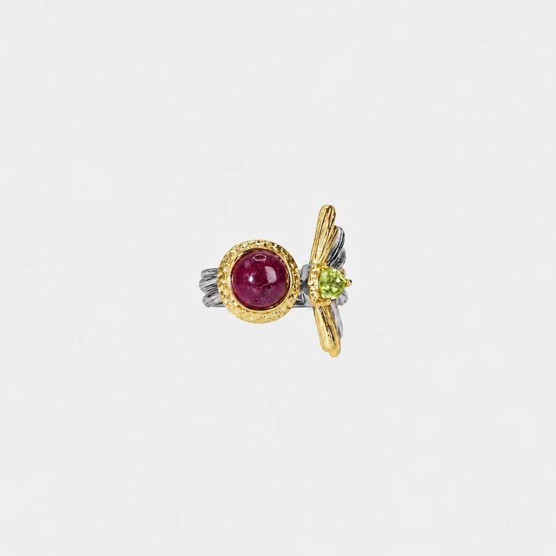 ONDA LENTA two-tone statement earring featuring a round red cabochon gemstone and faceted green gemstone with sculptural gold and silver details.